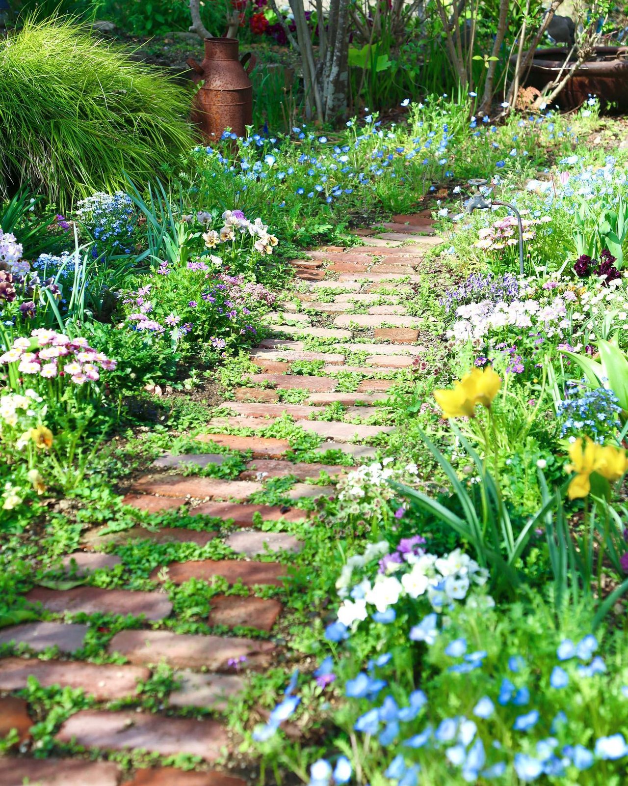 Brick garden path lined with colorful flowers