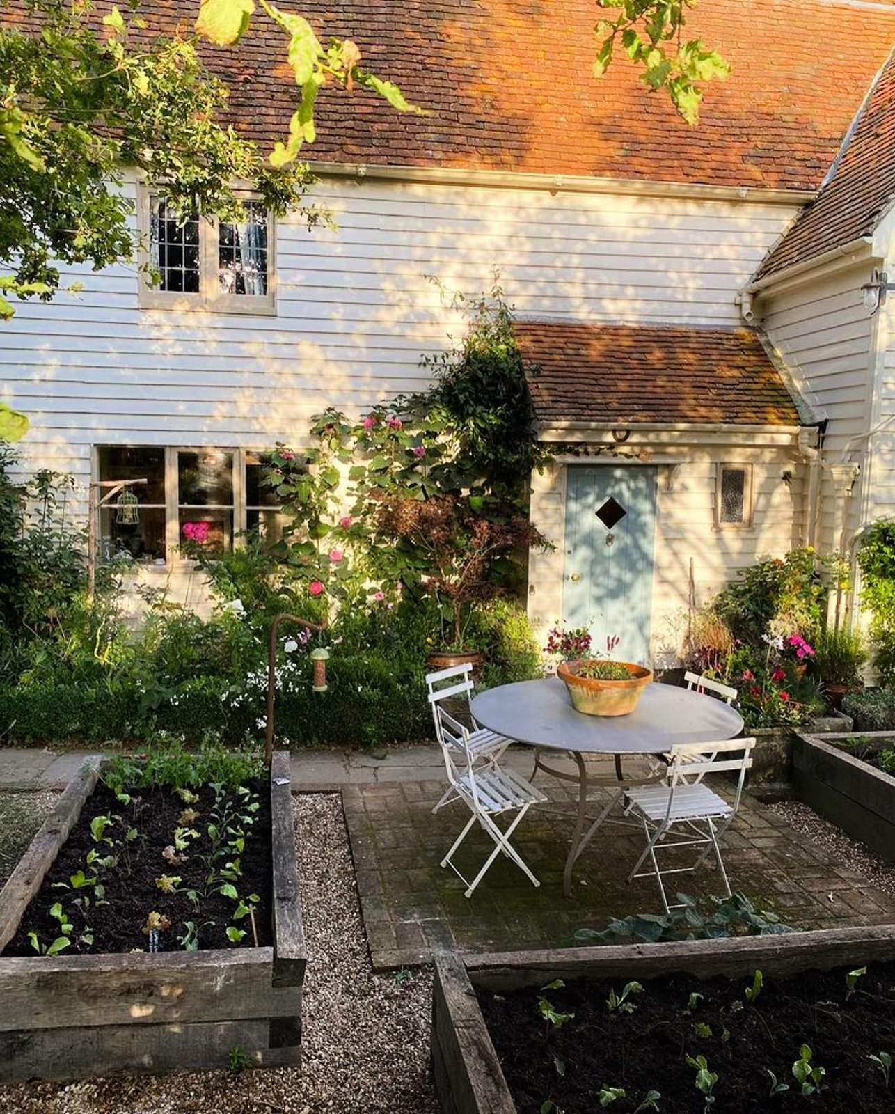 Cottage garden with raised beds and a patio table
